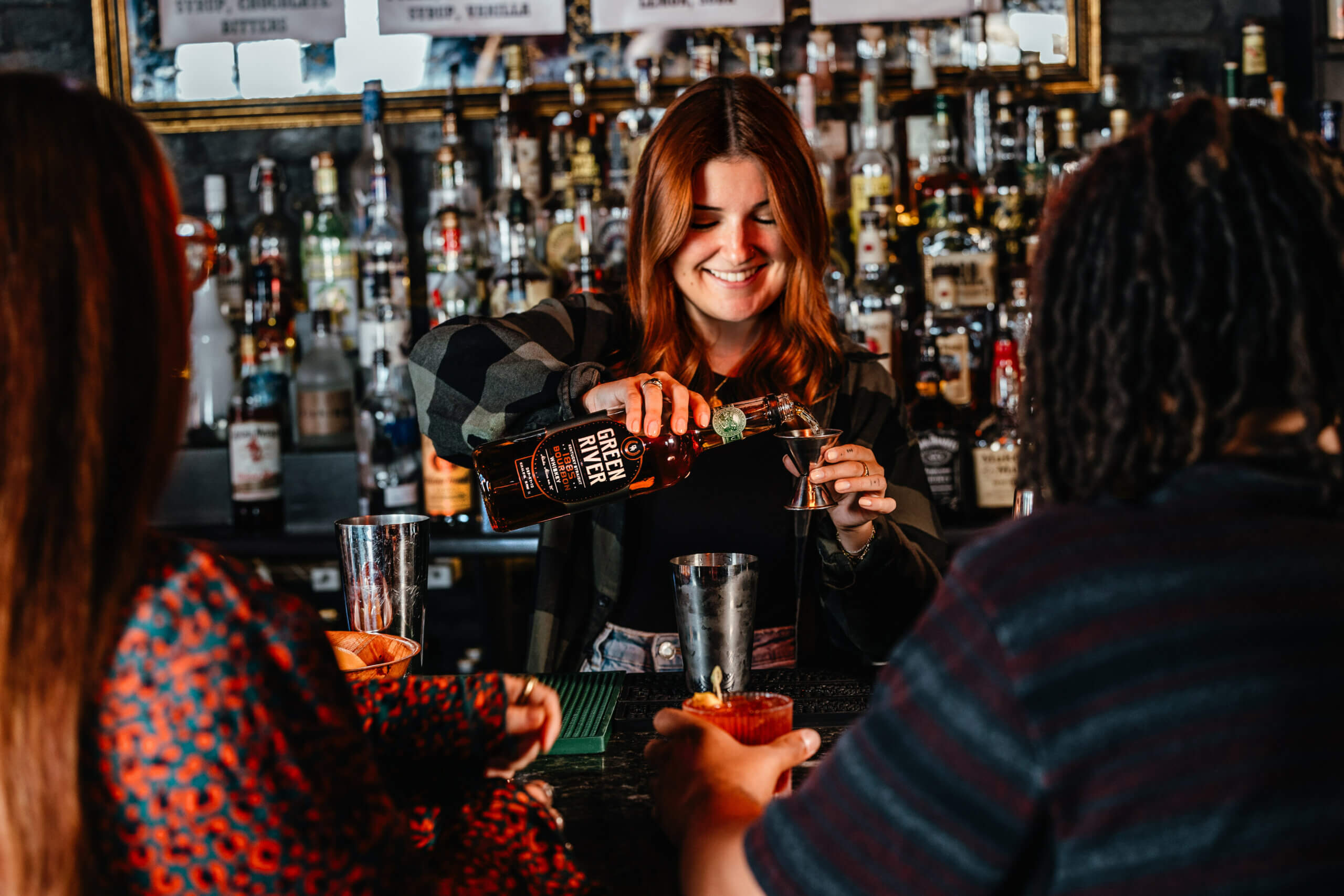 A bartender prepares a glass of whiskey sour with Bourbon from Green River.