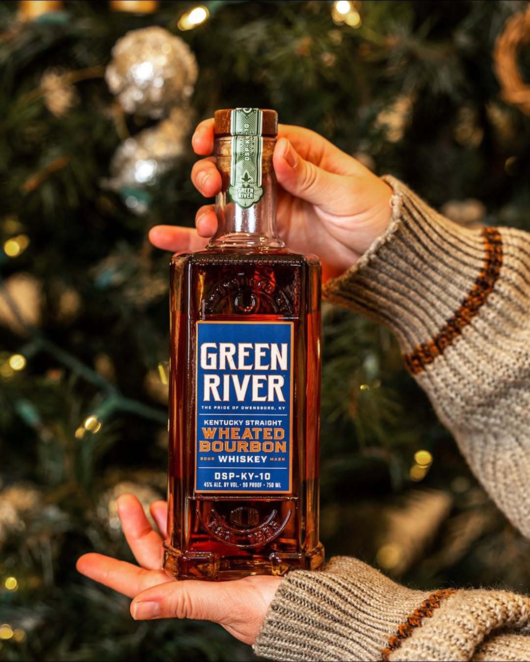 A person holds the Kentucky Straight Wheated Bourbon Whiskey from Green River.