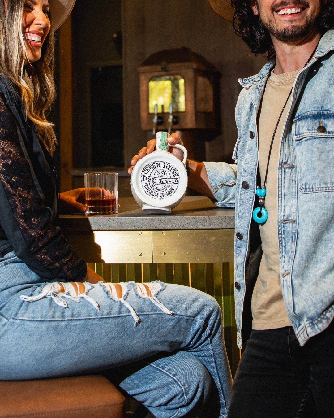 A happy couple enjoys a heartfelt conversation while sipping on whiskey from Green River.
