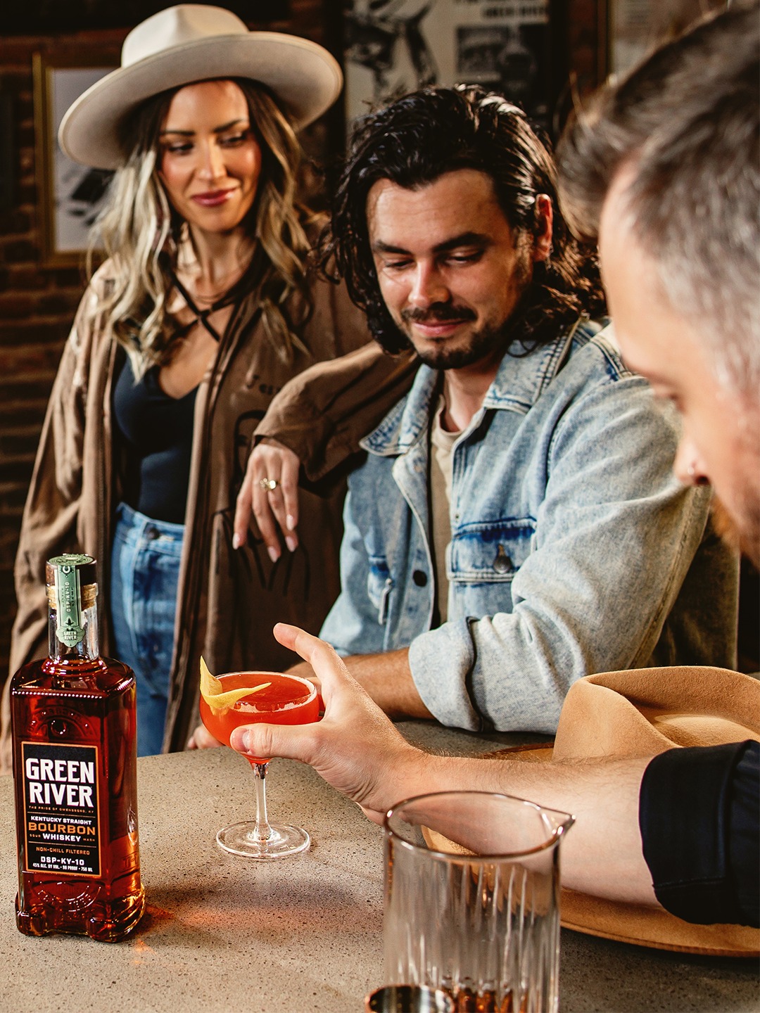 A group of friends enjoys cocktails and whiskey from Green River.
