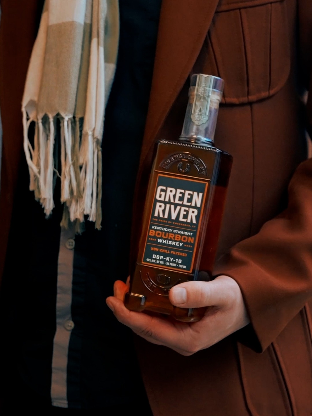 A person holds a bottle of Kentucky Straight Bourbon Whiskey from Green River.