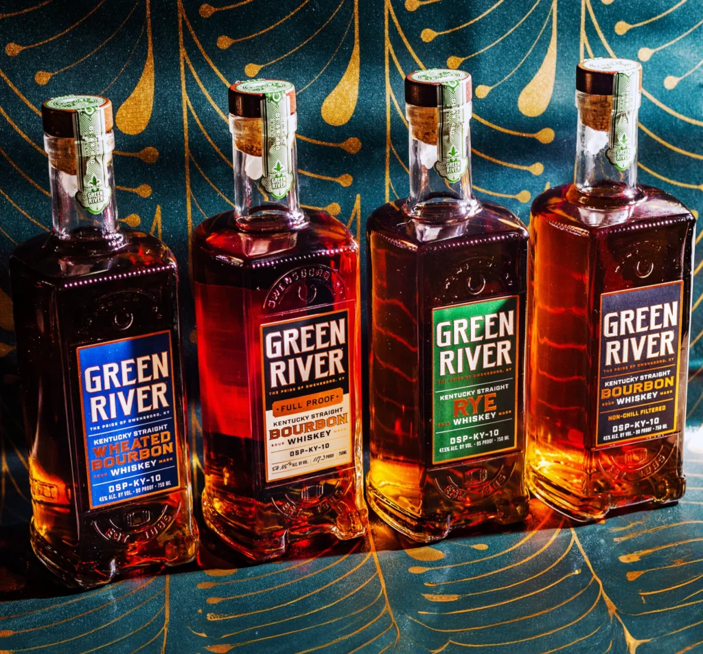 Four Green River bourbon and rye whiskey bottles lined up, each with green seals and black labels on brown glass.