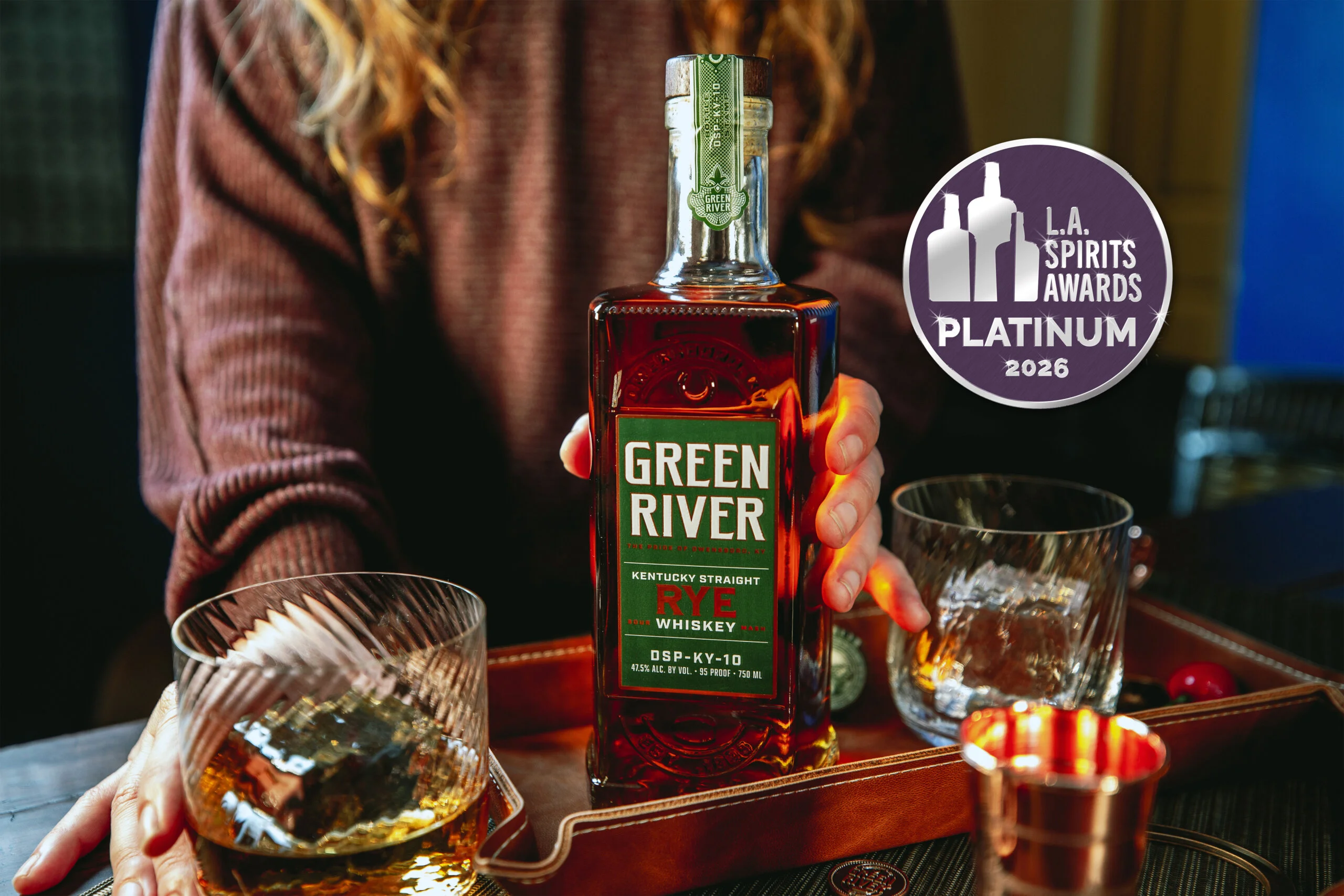 Green River Rye Whiskey bottle with Platinum award medal next to two glasses of whiskey.